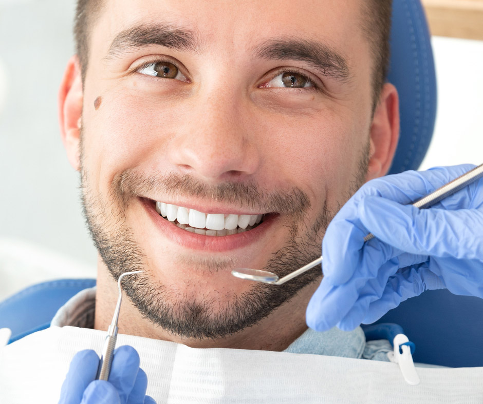 a man smiling for dental cleaning with a hand of dentist, Meridian, Idaho